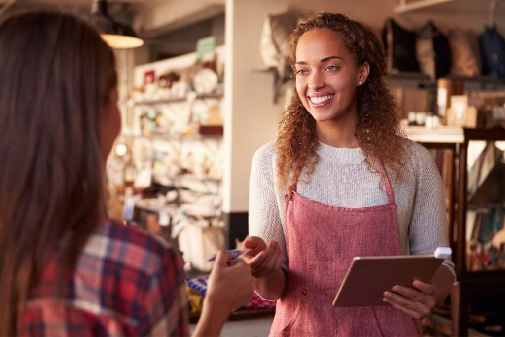 A shop owner attending to a customer. | A featured image from "What (Exactly) Is The Scope of Small Business Marketing" | BigCountryMarketing.com