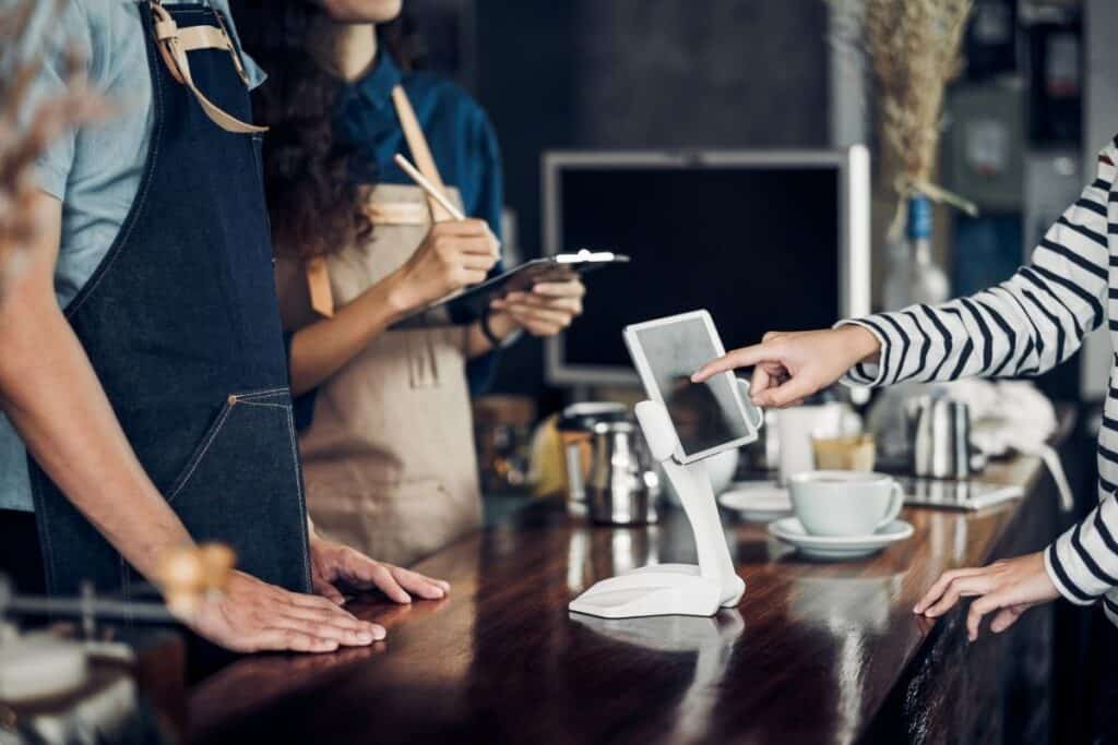 Local business owners taking a customer’s order at a neighborhood coffee shop. | A featured image from "How Should I Get Started With Local SEO?" | BigCountryMarketing.com